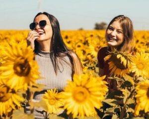 Femmes hypersensibles souriantes dans un champ de tournesols